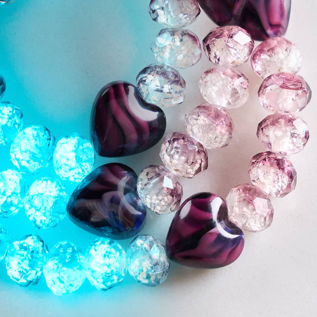 Plum glowing gradient hearts bracelet features purple striped heart beads and faceted glass beads glowing blue and pink by NOGU